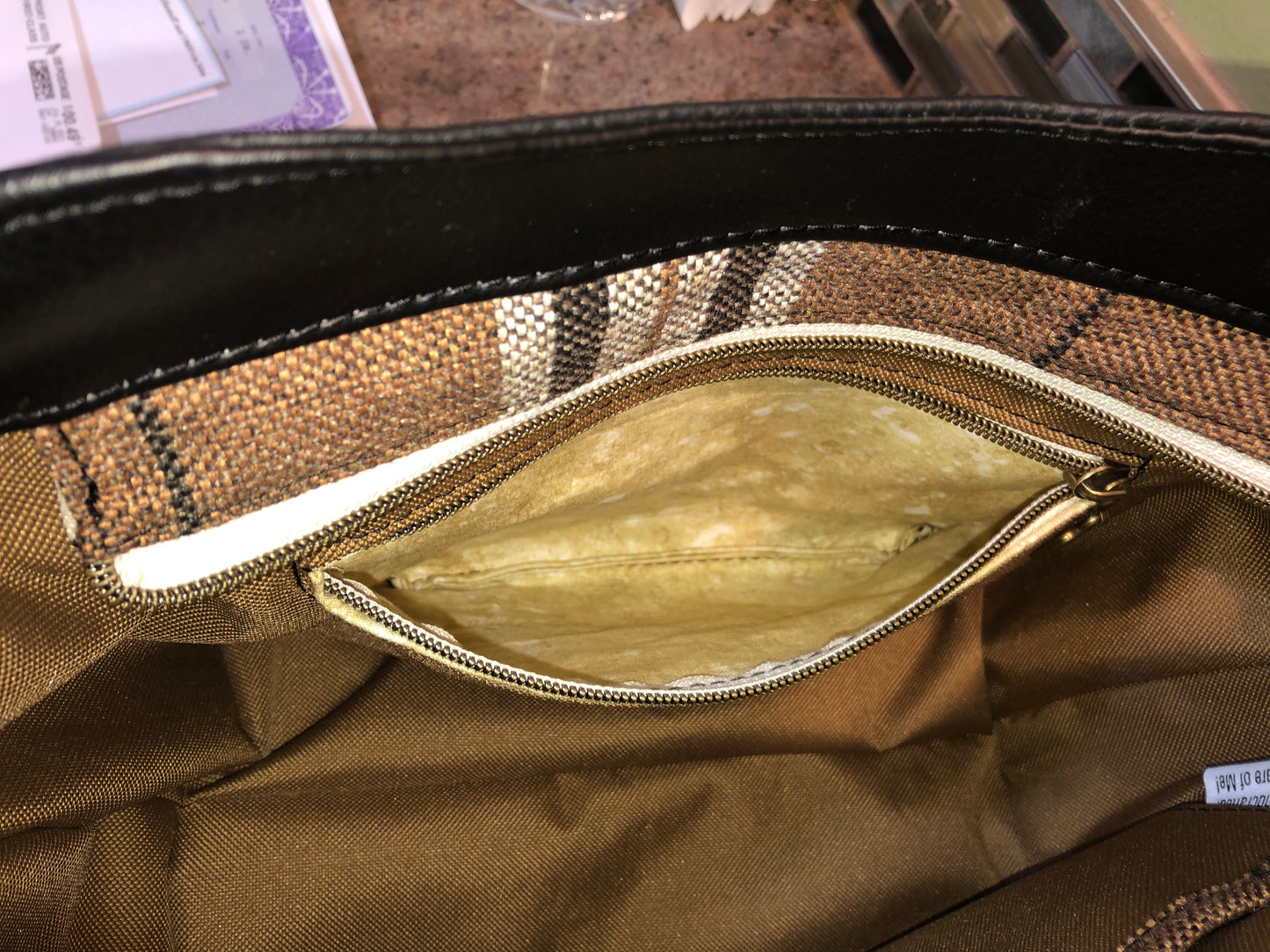 This classy brown and tan paid is a great everyday bag and even better a great bag for the fall season. Both vinyl and woven fabric come together on the sides to make a unique pattern. There is an adjustable, detachable crossbody strap. Top handles for crook of the arm or shoulder.