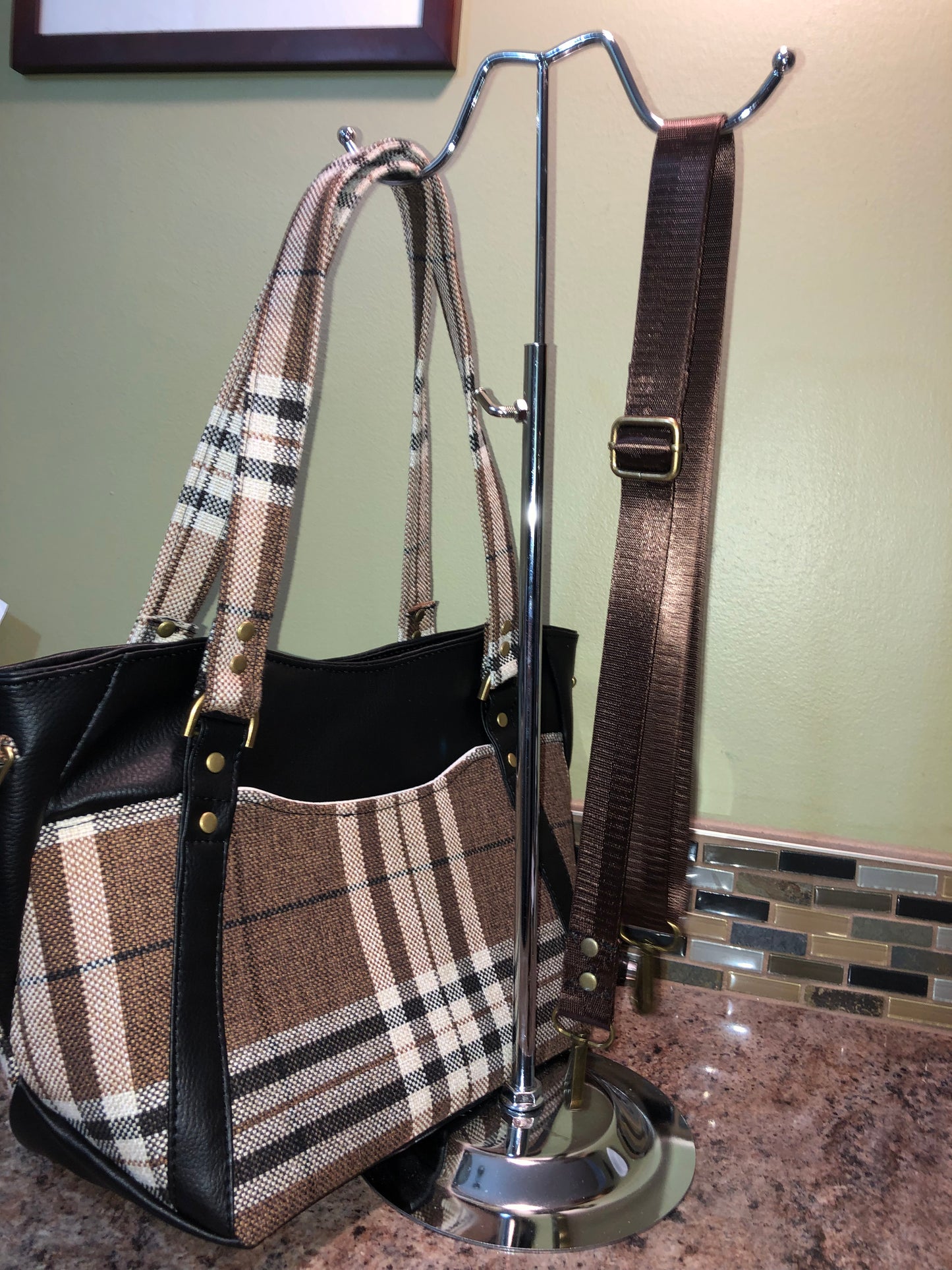 This classy brown and tan paid is a great everyday bag and even better a great bag for the fall season. Both vinyl and woven fabric come together on the sides to make a unique pattern. There is an adjustable, detachable crossbody strap. Top handles for crook of the arm or shoulder.