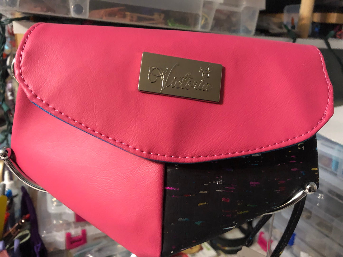 Pretty hot pink clutch with black and rainbow cork. Removable wristlet strap can go on either side of bag. 9" x 6" with four card slots and enough room for a cell phone. Magnetic heart shape snap front closure.