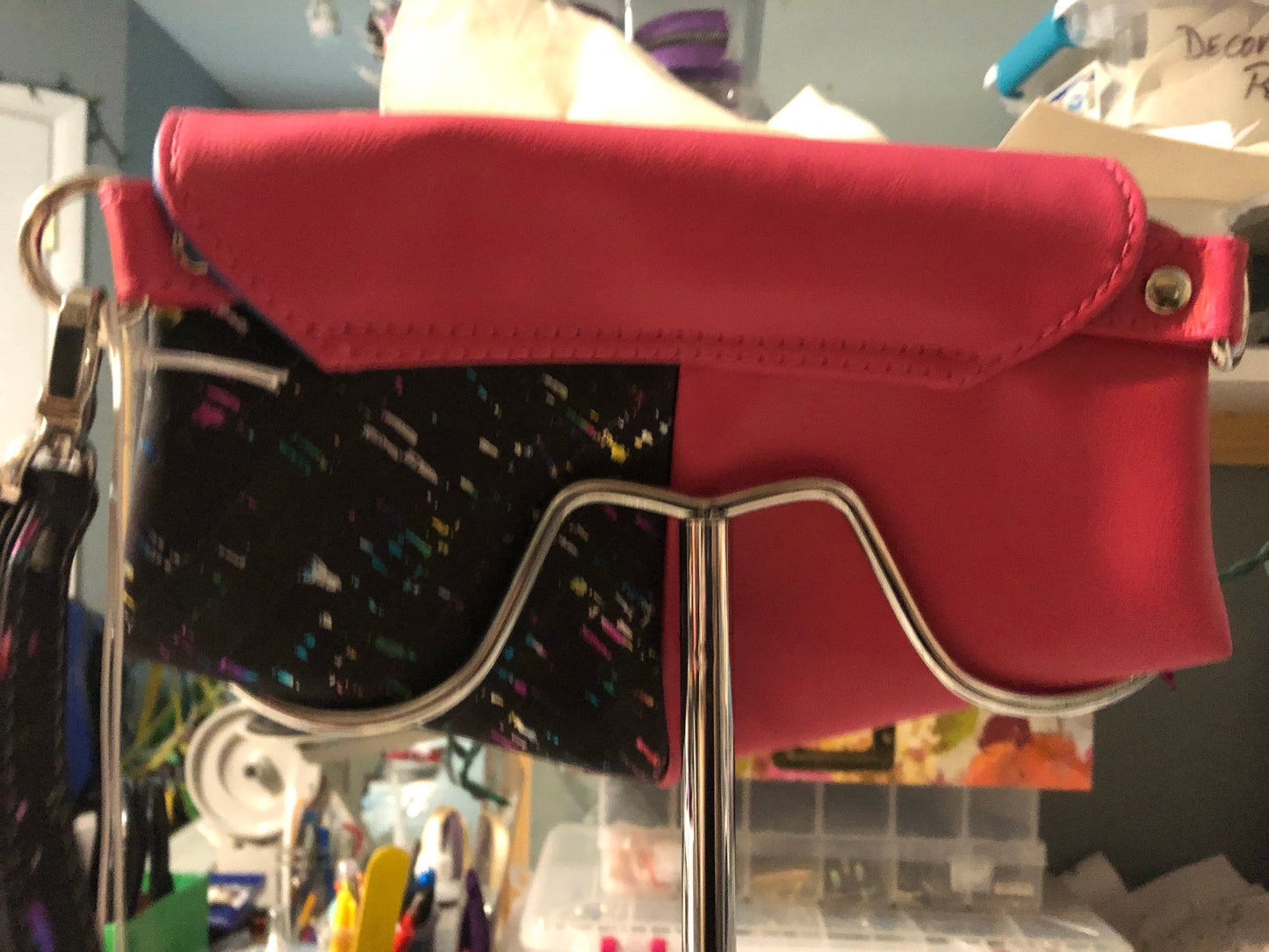 Pretty hot pink clutch with black and rainbow cork. Removable wristlet strap can go on either side of bag. 9" x 6" with four card slots and enough room for a cell phone. Magnetic heart shape snap front closure.