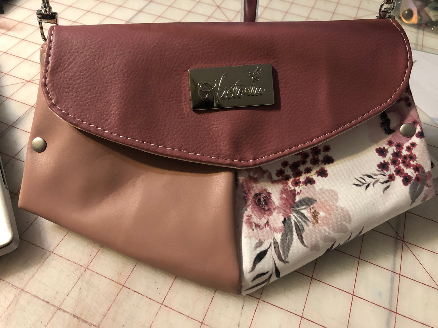 10" x 7" clutch mini purse/wallet on a chain. Card slots and enough space for a cell phone. Rosey mauve, light pink ad a beautiful cotton floral. Front snap closure. Use for an evening out with a wristlet strap or hands free with a shoulder legnth/cross body42" removable chain plus a removable wristlet strap 15" around.
