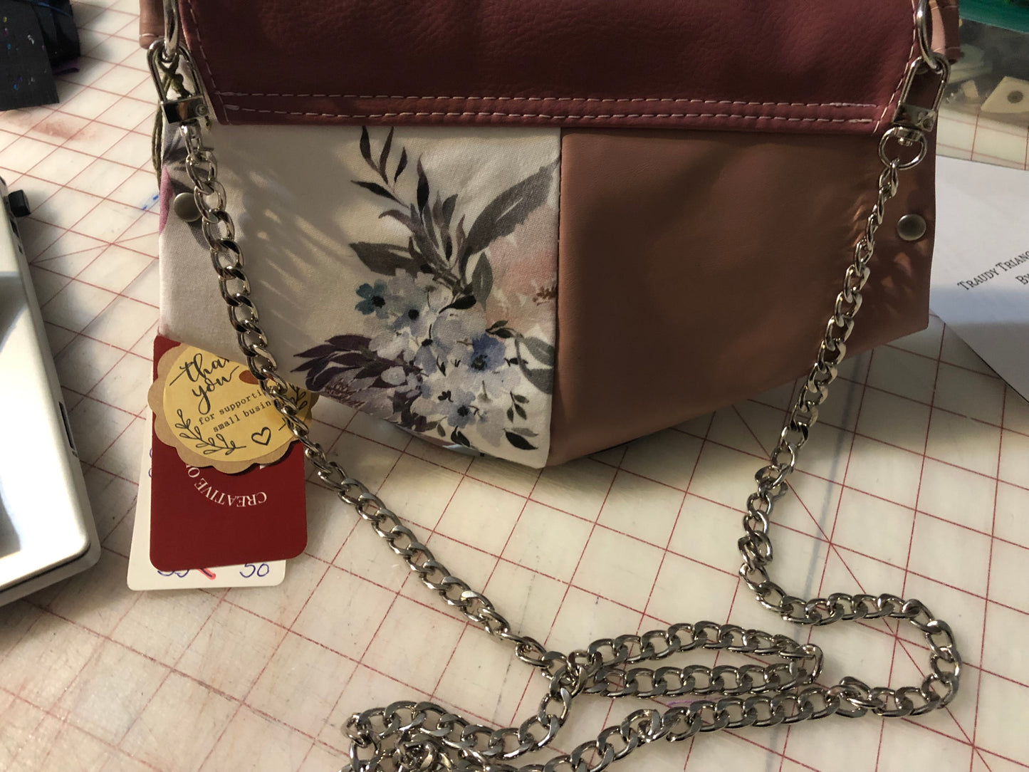 10" x 7" clutch mini purse/wallet on a chain. Card slots and enough space for a cell phone. Rosey mauve, light pink ad a beautiful cotton floral. Front snap closure. Use for an evening out with a wristlet strap or hands free with a shoulder legnth/cross body42" removable chain plus a removable wristlet strap 15" around.