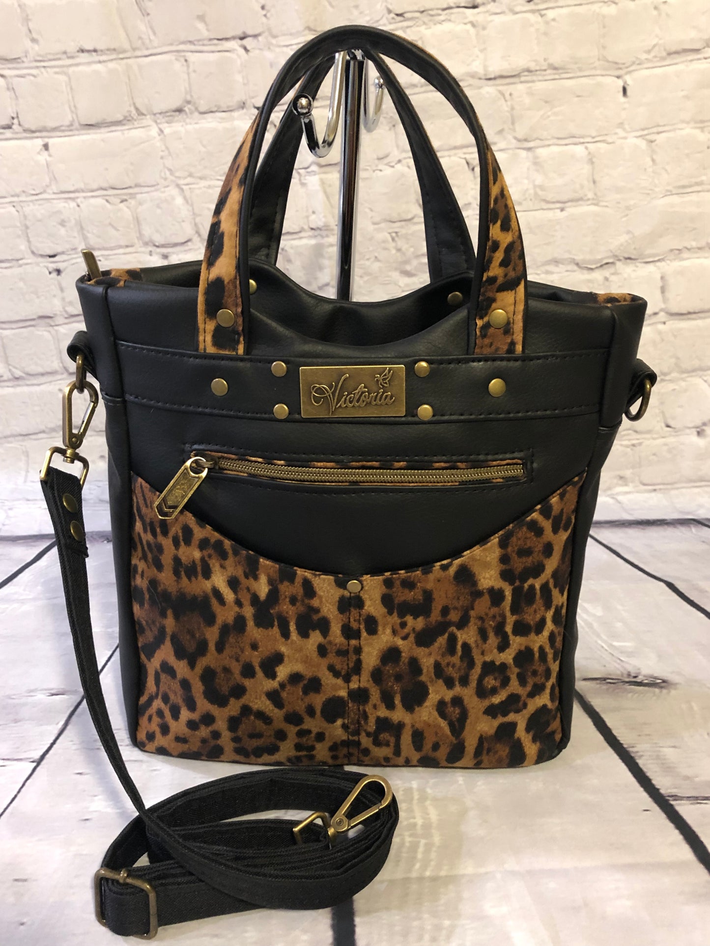 Womens handmade handcrafted handbag. Crossbody bag. Removable strap adjustable to shoulder length. The grab handles are two tone black and animal print. Antique gold hardware and rivits