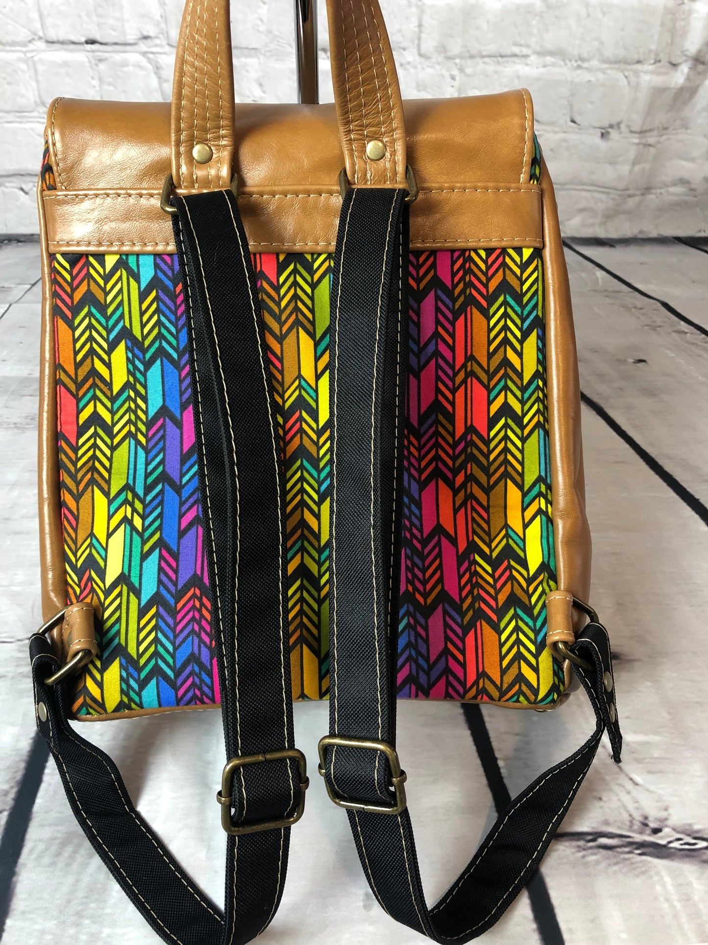 2 adjustable black canvas straps that match the fabric and canvas is strong and will not wear out and is very easy to slide yet it hold fast and will not slip.Meraki leather trim backpack with designer Anna Marie colorful fabric.