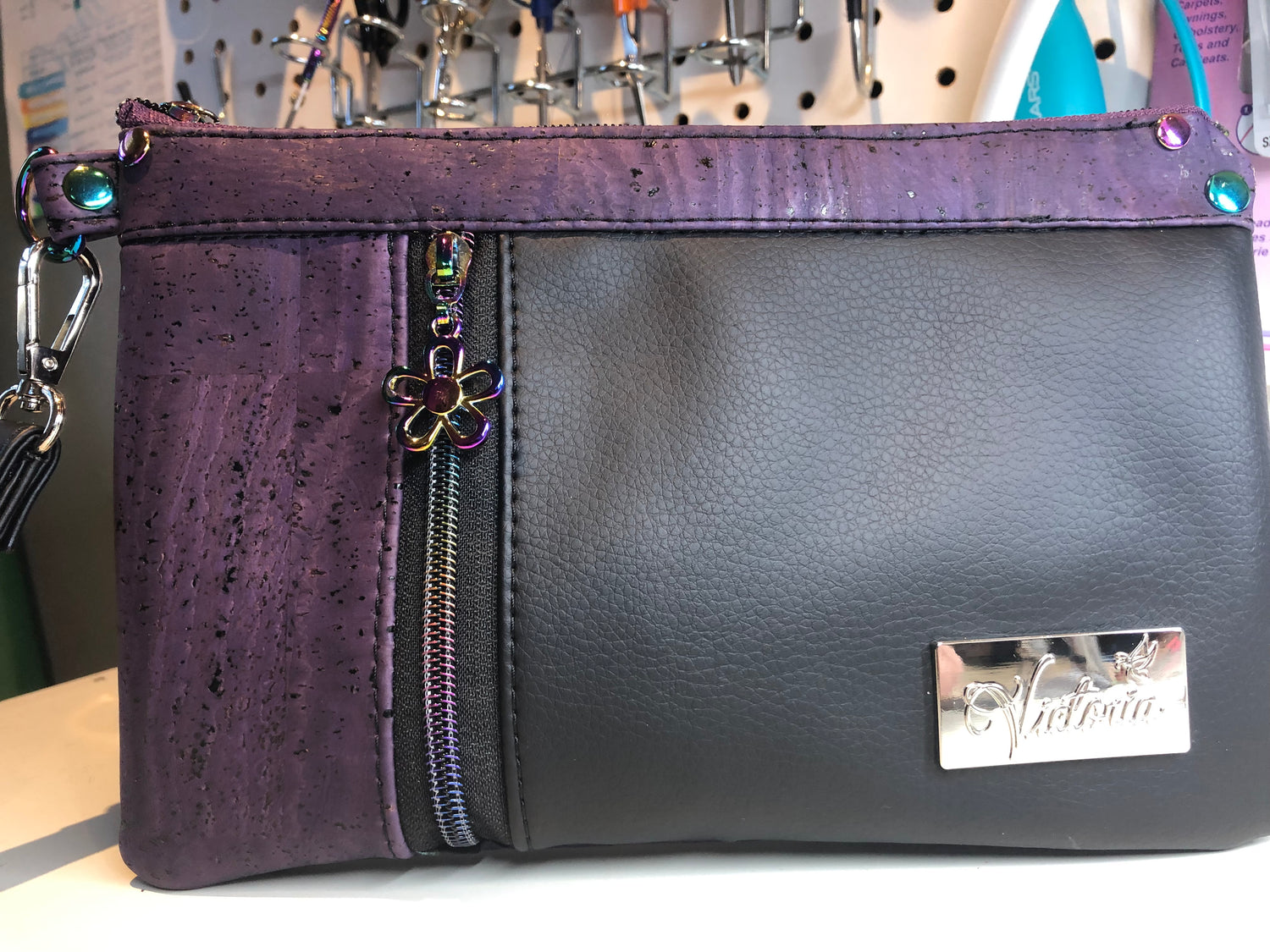 The left side of the zipper is usable space. You can keep tissues, or lipstick, cards, or bills. It's a 3" x 6" tall space. The right side of the front zipper is 6.5" wide and 6" tall. This beautiful shade of dark purple cork.  Cork is a natural  product that can have pit marks, and some color variation and other various markings that occur naturally.