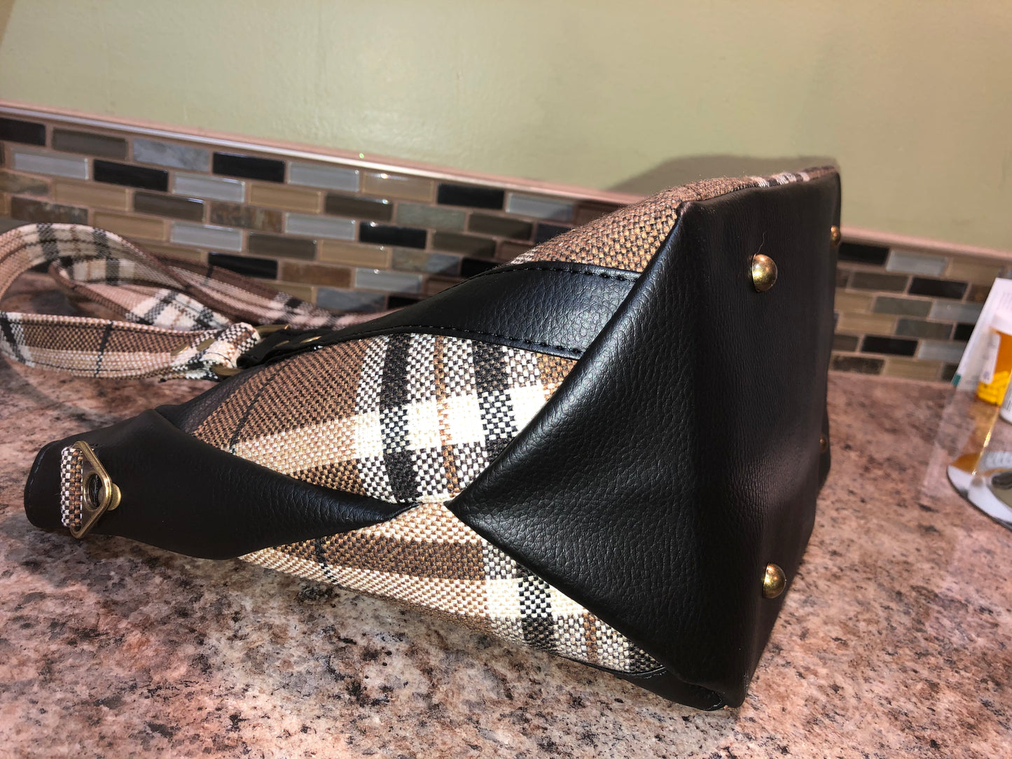 This classy brown and tan paid is a great everyday bag and even better a great bag for the fall season. Both vinyl and woven fabric come together on the sides to make a unique pattern.   There is an adjustable, detachable crossbody strap.  Top handles for crook of the arm or shoulder.