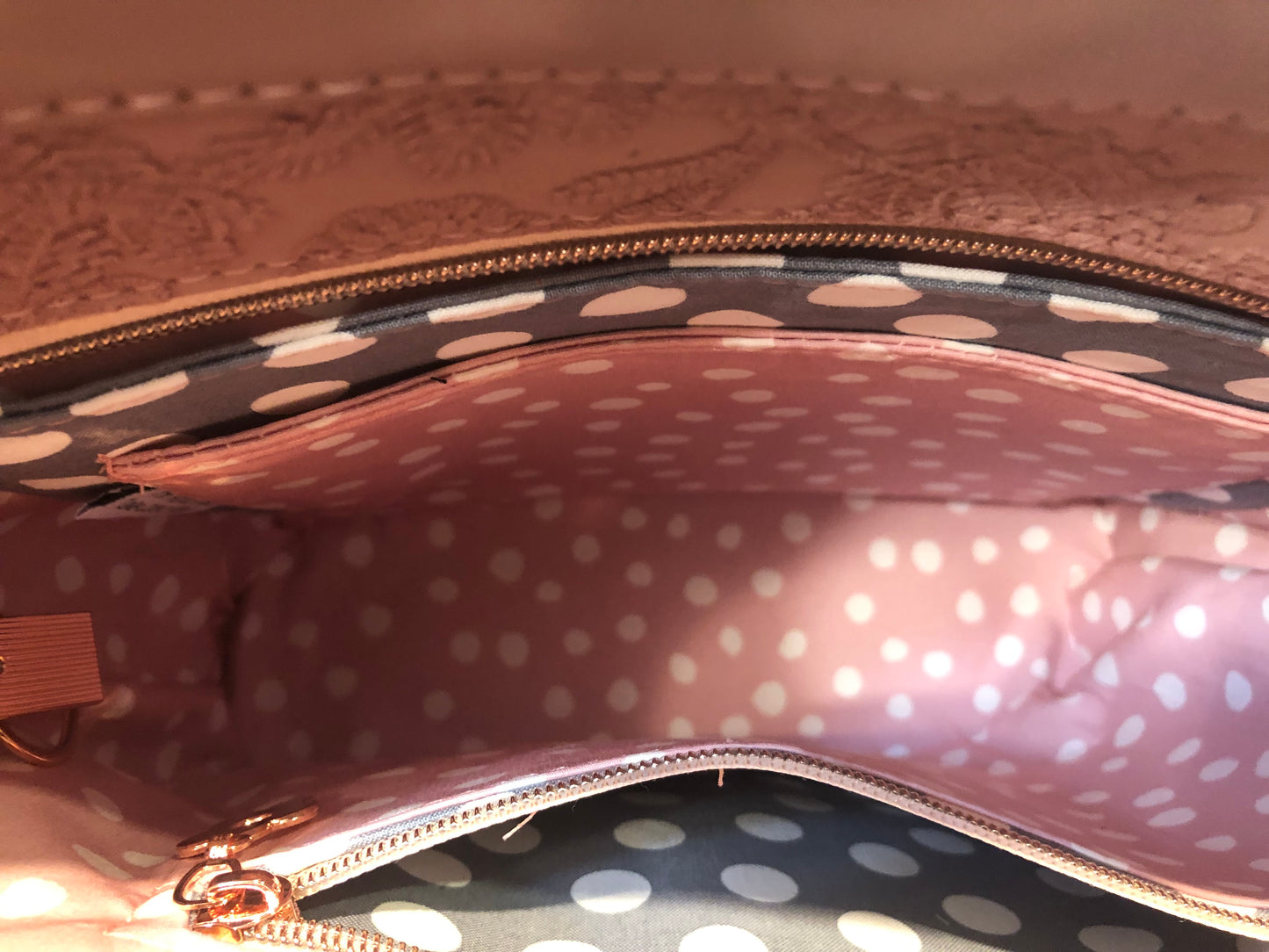 looking down into the Zoella handbag. Blush pink dot lining and gray dot slip pocket and zipper pocket with gray dot zipper pocket.