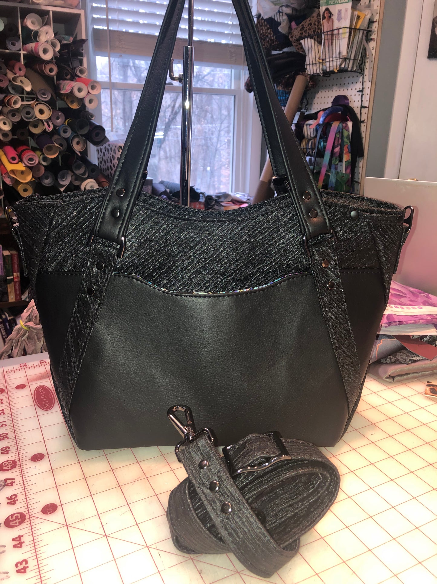 Black on black handbag. Main view. Disregard the shimmer look... The textured vinyl is picking up all sortts of light making it look shimmery.