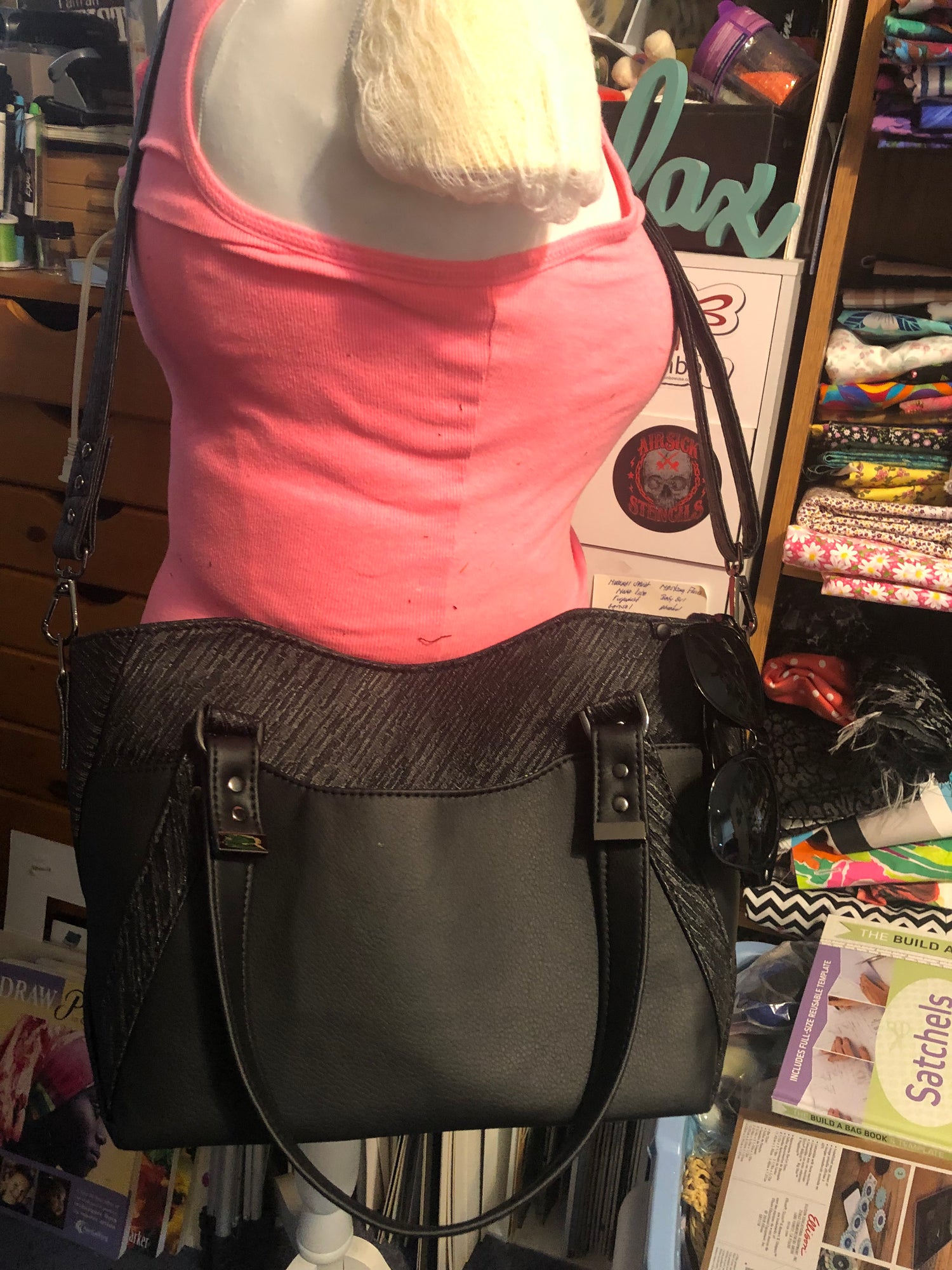 On manikin showing odd crossbody strap, metal strap ends, & sunglass loop