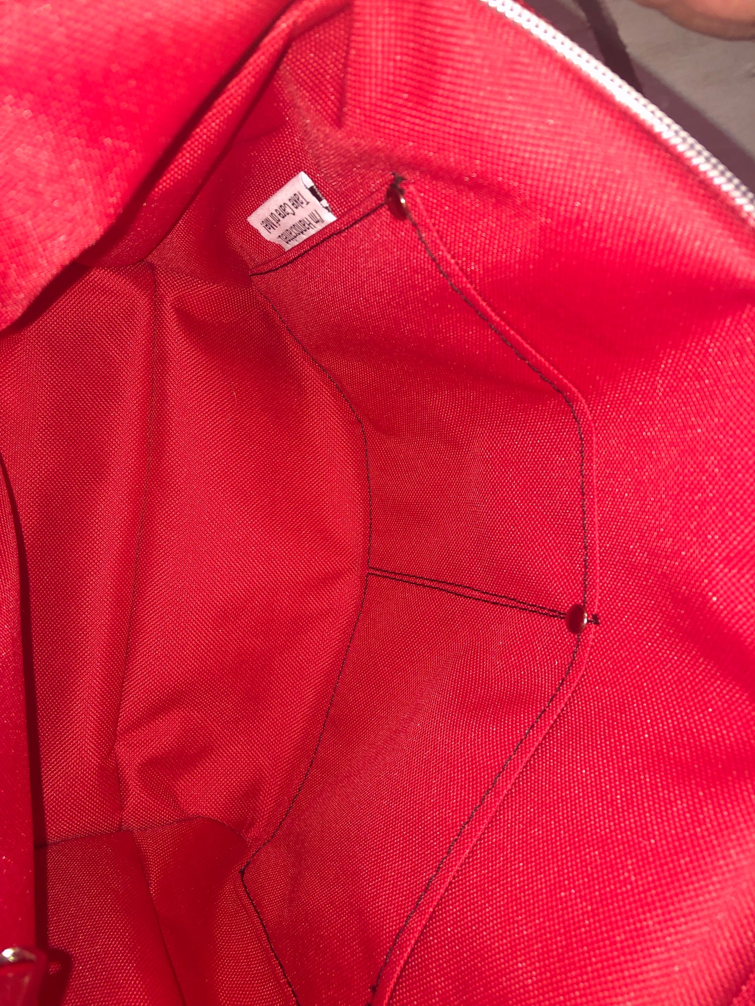 Red water proof canvas interior with a zipper pocket and a double slip pocket